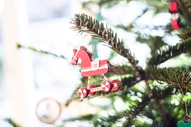 25 a menos de 25 dólares: Los mejores regalos para los días festivos para todos en tu lista, a partial image of a Christmas tree with a rolling horse ornament on it.